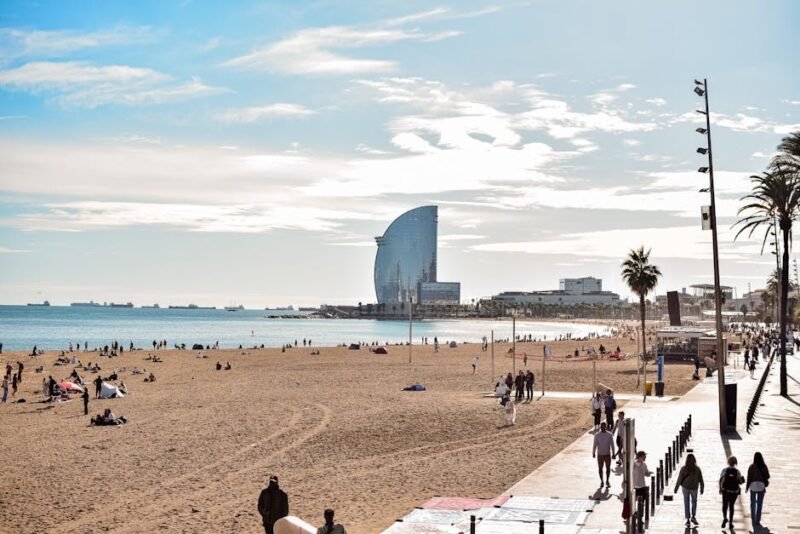 A vibrant day at Barceloneta Beach, showcasing the iconic W Hotel and lively atmosphere.
